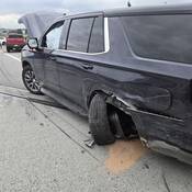 This damaged, black Chevrolet police SUV had its emergency lights on at roadside when it was hit by a driver who failed to Slow Down and Move Over