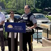 Photo of Staff Sergeant Chris Dodds, speaking at the podium on behalf of Southeast District RCMP.