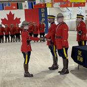 Cst. Morgan Lindsay receives her badge from her father at her Depot graduation ceremony in 2026.