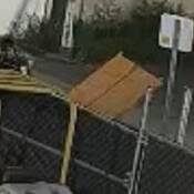 Image of person standing beside garbage dumpster