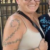Tania Langley with vine and flower tattoo on her arm