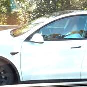 A still image from witness video that shows a woman who is allegedly asleep while driving a white Tesla