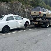 A white Toyota Corolla taxi being towed away from the Sea to Sky Highway for excessive speeding