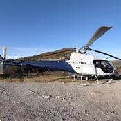 A blue and white helicopter on the ground.