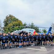 Photo of the riders in front of an RCMP helicopter.