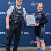 Photo of Inspector Monsef presenting a letter of commendation to one of the riders.