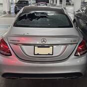 A silver Mercedes with its rear window smashed.