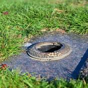 An empty hole on a grave marker where a vase used to sit.