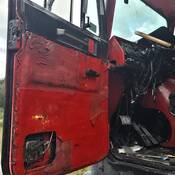The interior of a tractor unit with exposed and broken parts and a badly cracked windshield