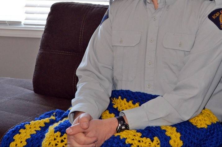 A man’s hands on a blue and yellow blanket.