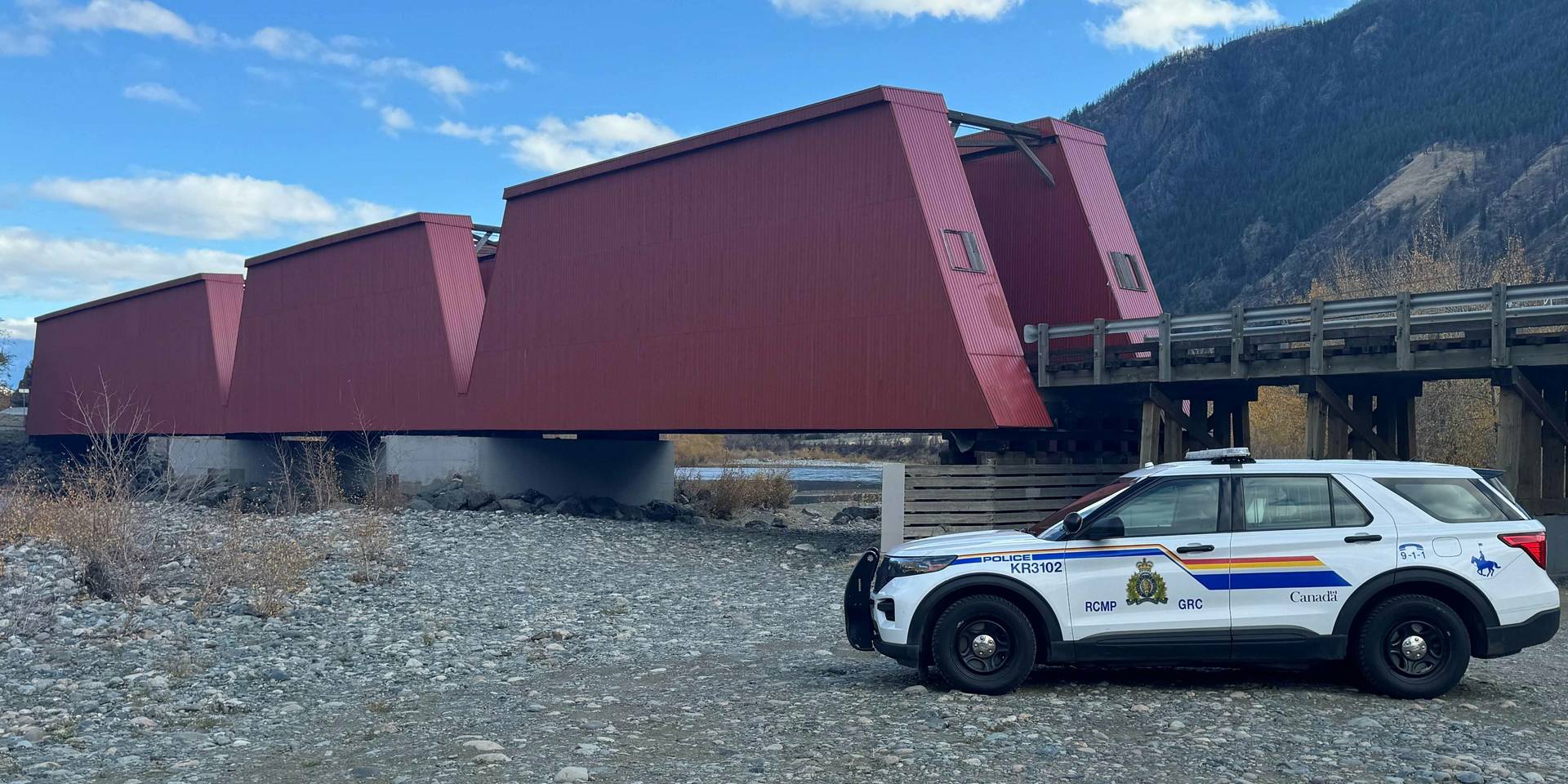 Keremeos RCMP police car parked by the historic Red Bridge with a