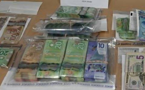 Several evidence bags with stacks of Canadian and US currency.