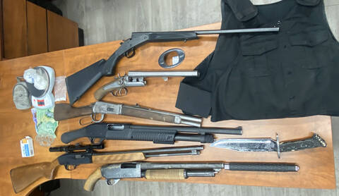 A photo of six guns laying on a table.