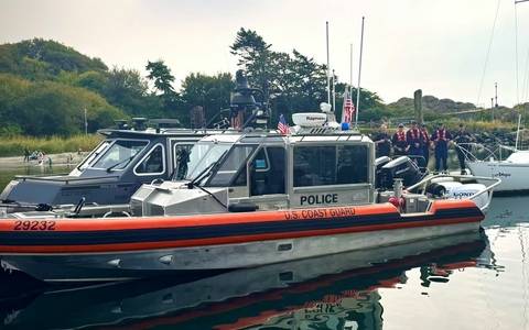 Photo of RCMP officers with the Marine Border Enforcement Team vessel and United States Coast Guard vessel