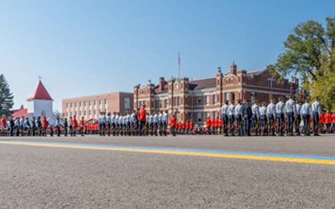 Troops in various uniforms on Parade Square on a sunny morning.