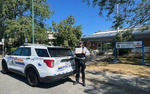 RCMP officer Sandhu next to police SUV in front of RCMP detachment