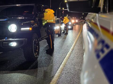 Photo of police officers speaking with drivers at a road check