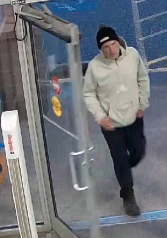 Photo of man wearing black toque, white hoodie and black pants