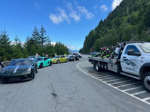 Thumbnail: Four impounded Porsches are lined up on Highway #99 waiting for a tow truck, while a tow truck loaded with two motorcycles prepares to leave for the impound lot