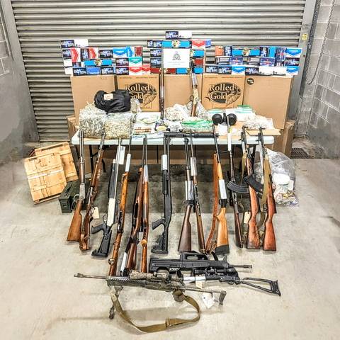 Photo of seized cigarettes, firearms, ammunition, drugs and cash.