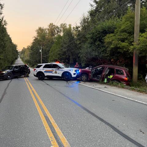 Police car on road and red SUV in ditch