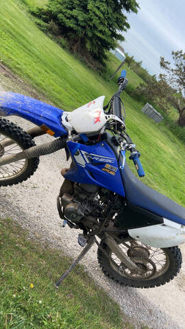 Stolen blue and white 2013 Yamaha dirt bike with NL licence plate KAN954 parked on grass