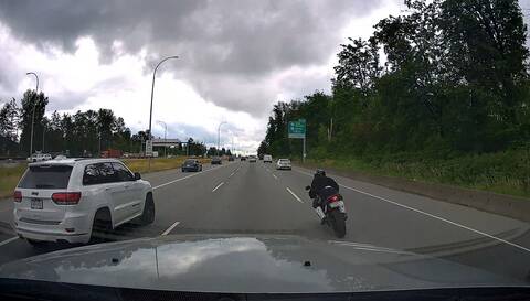 A motorcycle makes an unsafe lane change in heavy traffic on Highway #1, as seen by a witness vehicle’s dash camera