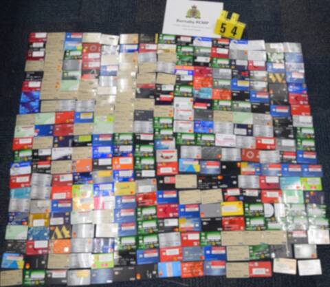 Over three hundred blurred bank cards displayed on the floor.