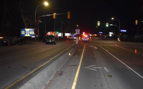Police vehicles and police officers on foot investigate the aftermath of a fatal collision at the intersection of Highway #1 and Boys Road