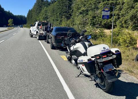 A BC Highway Patrol motorcycle impounds the vehicle of a high risk driver at the side of Highway #99