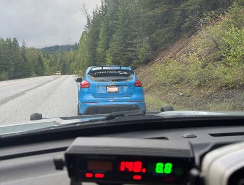 Thumbnail: A dash camera photo of a blue hatchback stopped by police. The police radar shows a speed of 148 km/h