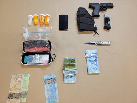 Display of seized drugs, cell phone, cash, weapons and a firearm