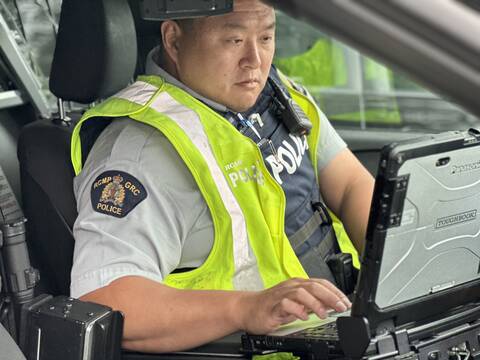 Richmond RCMP officer inside a police vehicle using a computer