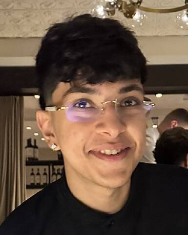 Man with short black hair, black shirt and glasses.