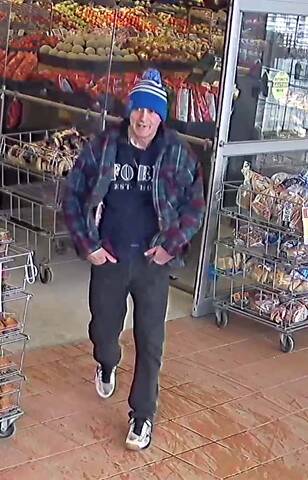 Surveillance image of an unidentified male suspect walking through the entry/exit of a grocery store in Grand Falls-Windsor