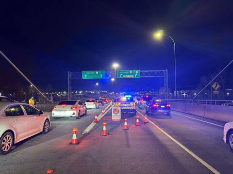 Police officers checking drivers for impairment with the sign “Counterattack Road Check Ahead”