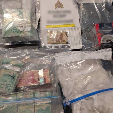 Bags of white powdered substance and money on table | Sacs contenant une substance blanche en poudre et argent sur la table