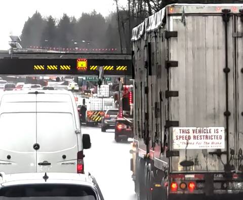 White flatdeck truck whose crane boom struck the CP Rail overpass on Highway 1 in Langley