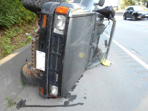 An older Toyota pickup truck rolled on its side on Highway #1