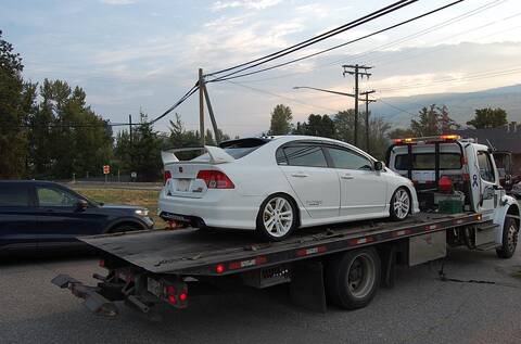 This white Honda Civic, being loaded onto a tow truck while a black BC Highway Patrol vehicle supervises, was impounded for going triple the speed limit