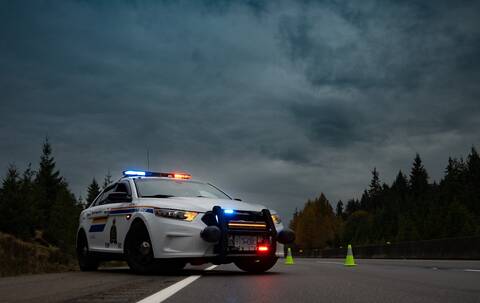 A BC Highway Patrol cruiser blocks the highway with its emergency lights activated