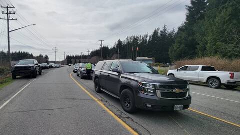 Unmarked BC Highway Patrol cruisers straddle the highway as a Mountie prepares to pull over a vehicle during a JFO in Tofino and Ucluelet
