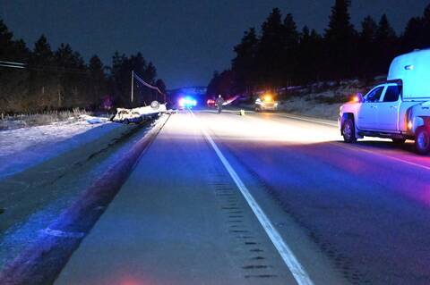 BC Highway Patrol vehicles and officers at the scene of a deadly crash on Highway #3/#93 between a white pickup and a grey Pontiac
