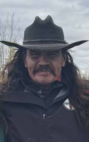 Adult male with long brown hair, brown eyes, and a moustache.
