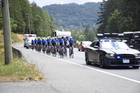 Photo of Tour de Rock riders on highway escorted by police during Mock Tour