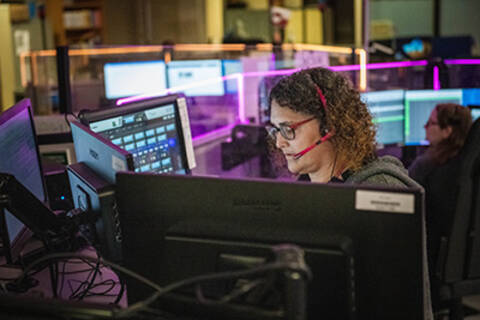 Woman sitting at a desk. | Une femme assise à un bureau.