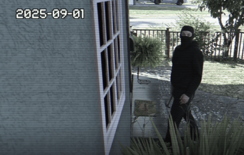 Thief standing in front of home, holding a hammer