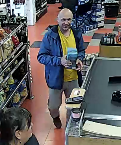 The suspect is described as bald, with medium skin, approximately 40-50 years of age, wearing a yellow t-shirt, blue jacket and grey pants.