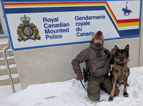 PSD Mako with his handler in front of the Fort St John RCMP sign in the cold and snow