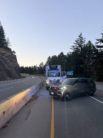 Transport truck stopped with unmarked police vehicle in front